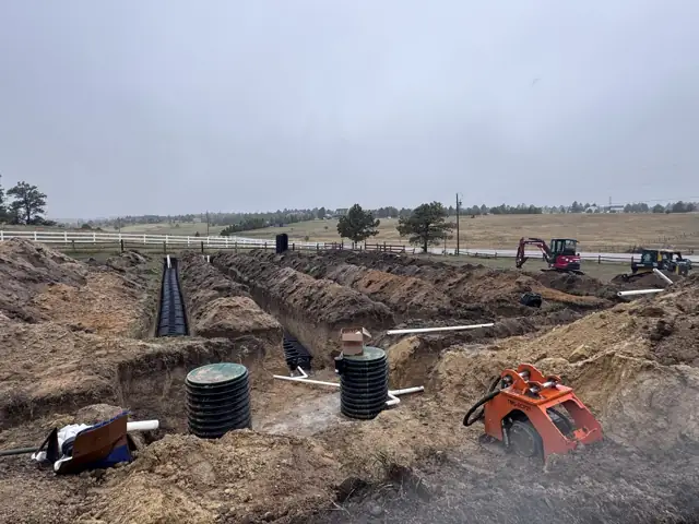 Septic installation site with tanks, trenches and a compact excavator