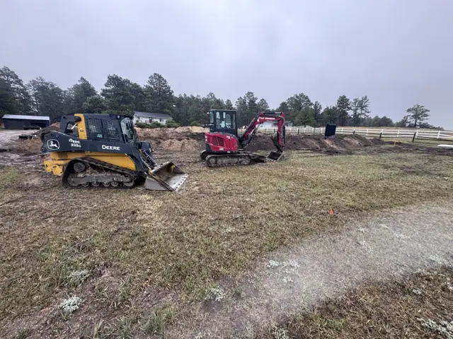 Track loader and compact excavator on a rural job site